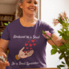 Kindness is a Seed - Be a Seed Spreader in Heather Purple Short Sleeve T-Shirt. Female model is trimming flower stems for bouquet in vase.