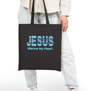Jesus Warms My Heart Canvas Tote in Black held by model