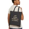 “Not Every Disability Is Visible” Canvas Tote in Black held by a male model