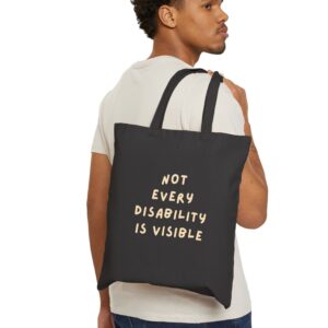 “Not Every Disability Is Visible” Canvas Tote in Black held by a male model