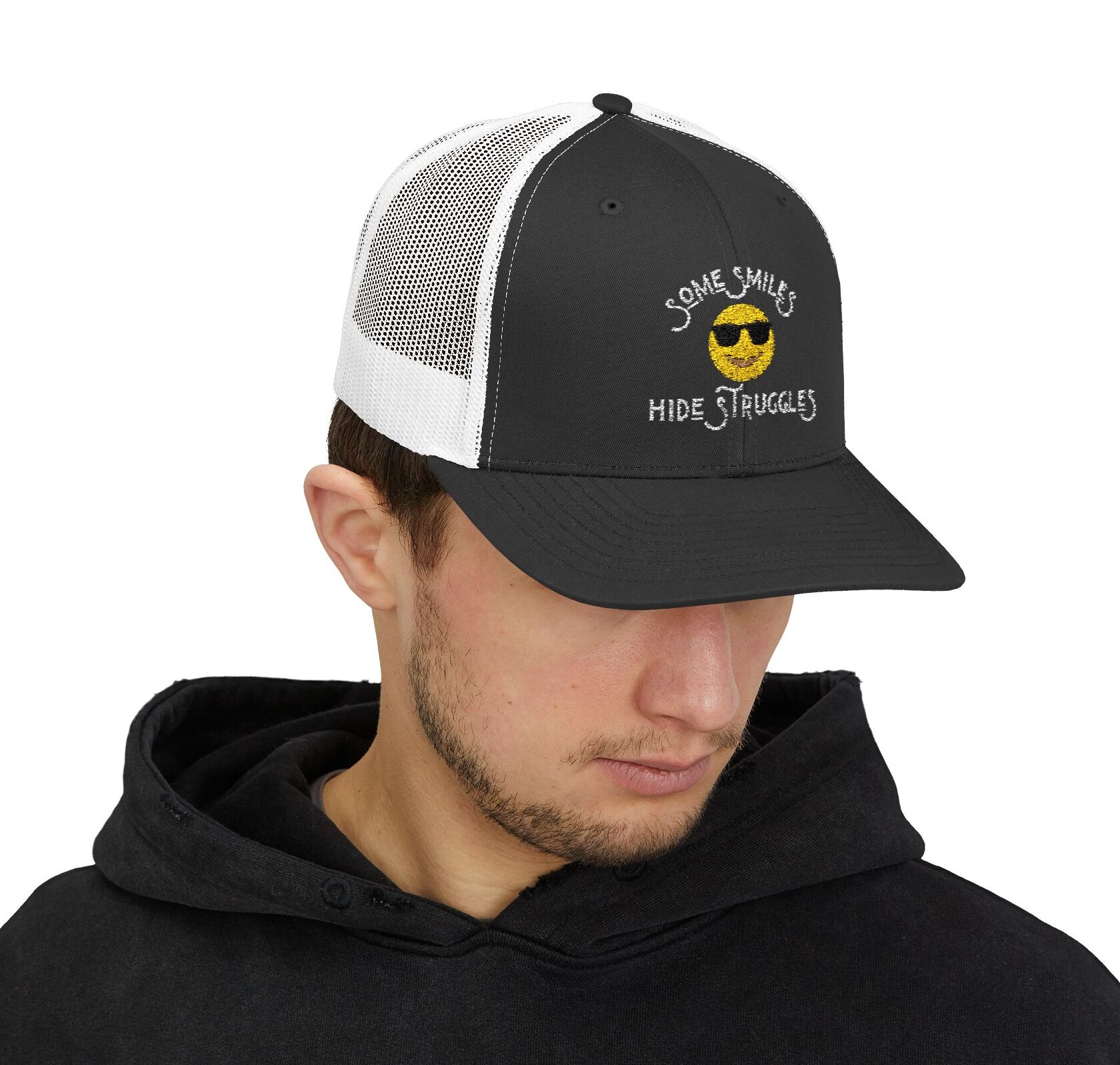 "Some Smiles Hide Struggles" Embroidered Trucker Cap in black/white on male model